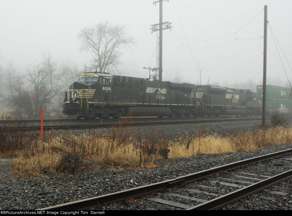 NS 8026 heads west in the fog on 27P